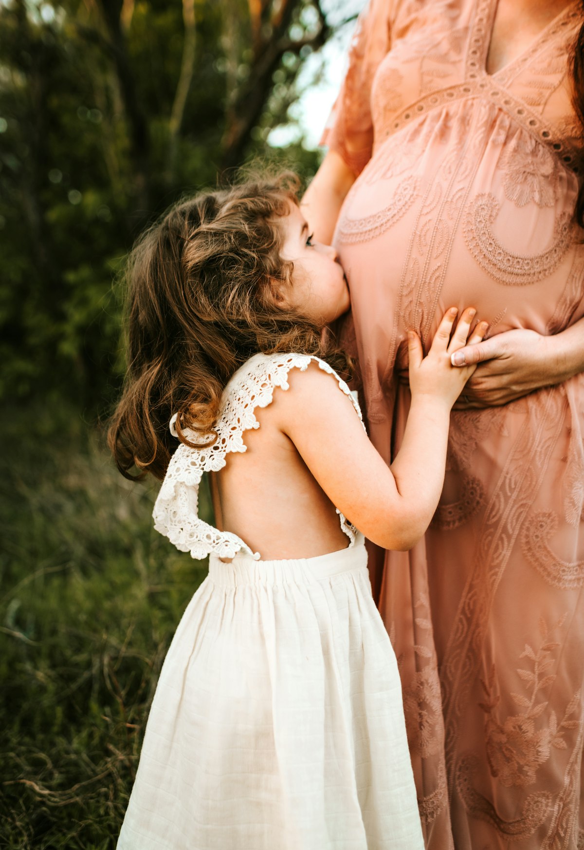 子どもが妊婦のお腹に寄り添うマタニティフォト。産休・育休中の家計管理をイメージ
