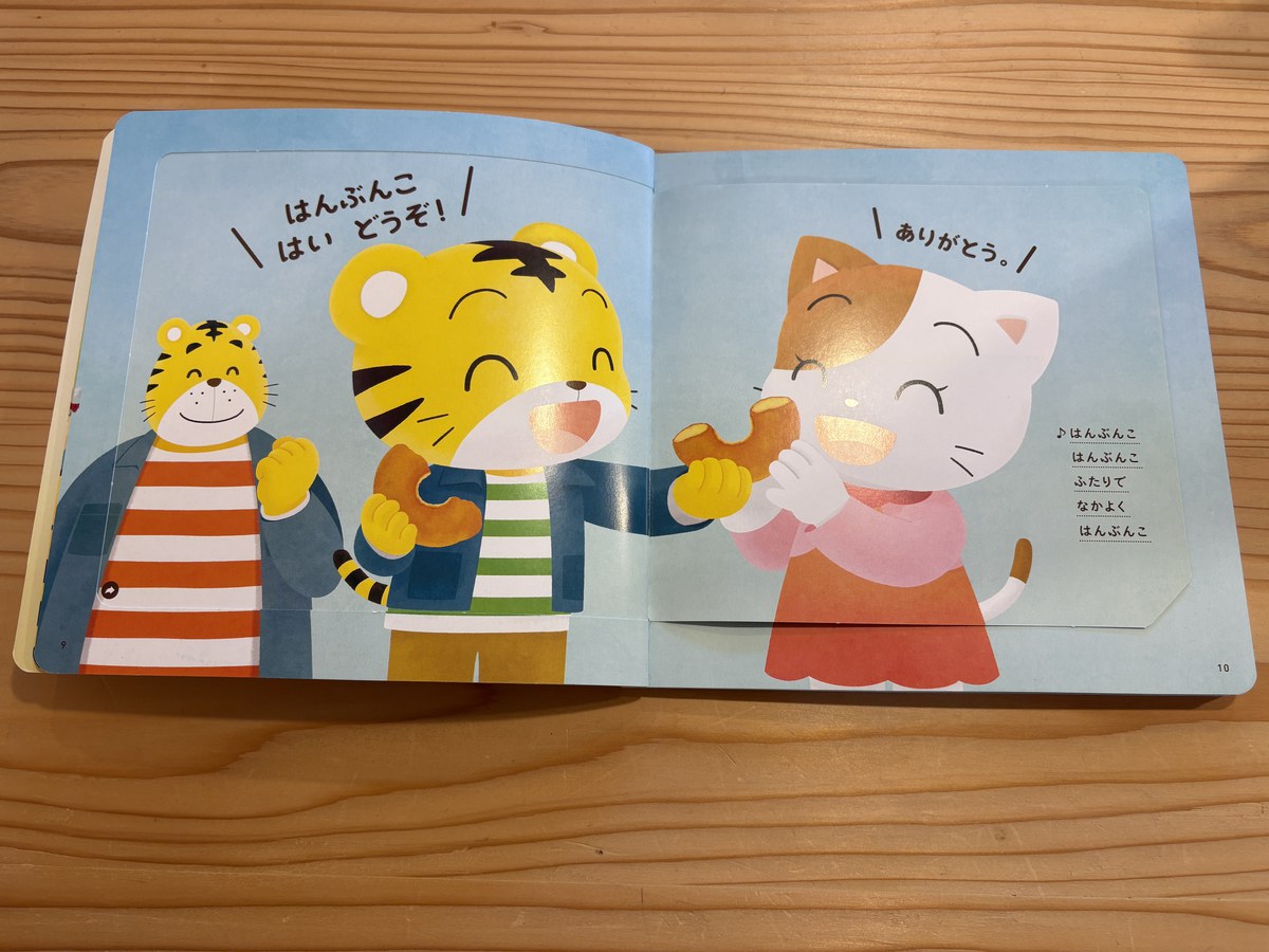 しかけをめくると、しまじろうが「はんぶんこ はい どうぞ！」、ねこちゃんが「ありがとう。」と言う場面が出てくる