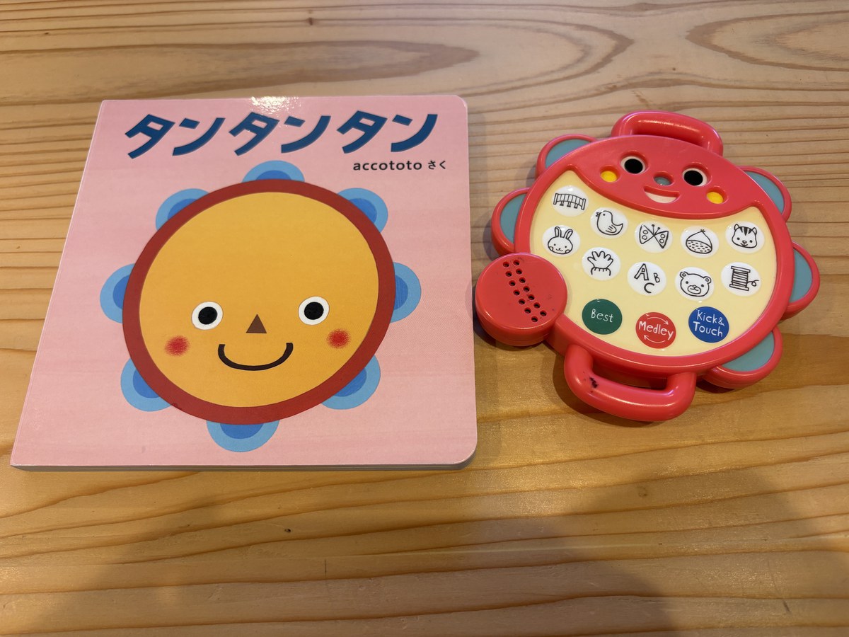 こどもちゃれんじbabyのころに届いた絵本『タンタンタン』と、音楽が流れるタンバリンの形のおもちゃ